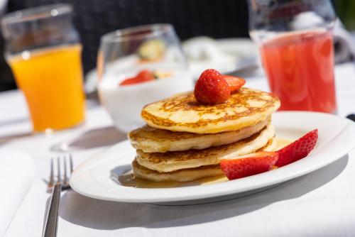 a plate of pancakes with strawberries on a table at Hotel Meandro - Lake View in Gargnano