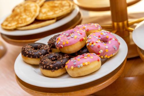 a plate of donuts and waffles on a table at Hotel Meandro - Lake View in Gargnano