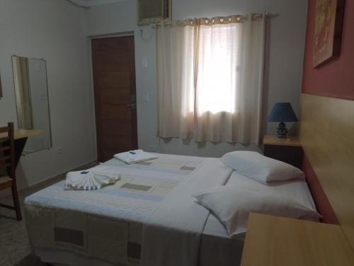 um quarto com 2 camas e uma janela em Hotel Venice Ubatuba em Ubatuba