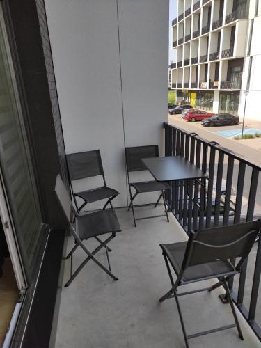 trzy krzesła i stół na balkonie w obiekcie Apartament AirPort we Wrocławiu