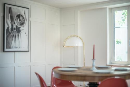 a dining room with a table and red chairs at Tilia Apartments in Uster