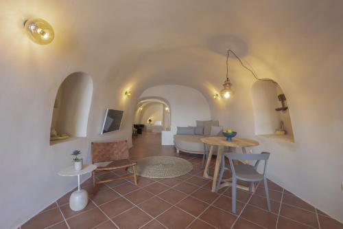 a living room with a table and a couch at Oia Waves by SV in Oia