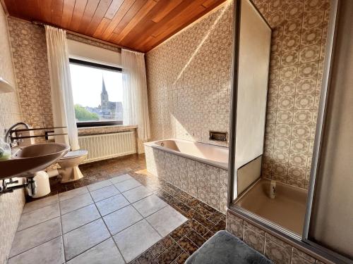 a bathroom with a tub and a sink at Landgasthof Zum Anker in Langenfeld