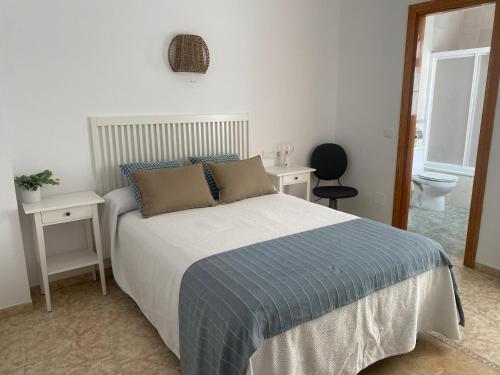 1 dormitorio con 1 cama, 2 mesas y aseo en Hostal Andalucia en Nerja