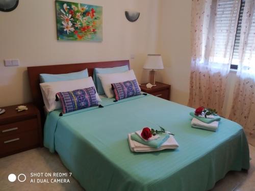 a bedroom with a bed with two towels on it at Sunshine Apartment Alvor in Alvor