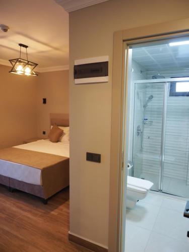 a bedroom with a bed and a bathroom with a toilet at ZENİA OTEL in Antalya