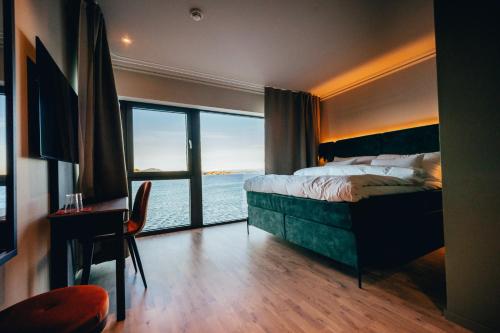 a bedroom with a bed and a view of the ocean at Biologen Herdla in Herlø