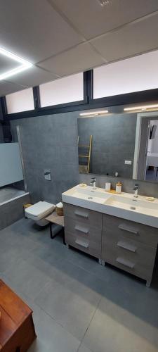 ein Badezimmer mit 2 Waschbecken und einem Spiegel in der Unterkunft Chalet con piscina, terraza y barbacoa in Pallaresos