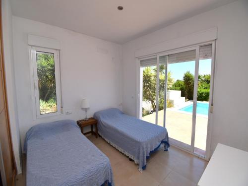 1 dormitorio con 2 camas y vistas a la piscina en Casa la Finca en Jávea