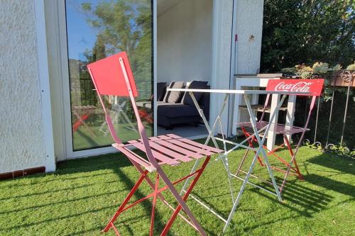 dos sillas de cocacola y una mesa de cocacola en el césped en Jolie T2 en Provence entre Marseille et Cassis, en Aubagne