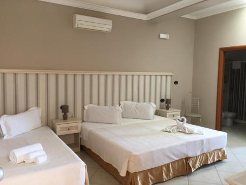 a bedroom with two beds with white sheets at Il Tempio Di Hera in Marinella di Selinunte