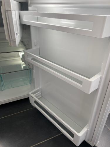 an empty refrigerator with its door open and its drawer at Apartment Sonnenschein in Allersberg