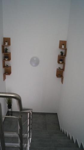 a staircase with a white wall with wooden shelves at Pokoje do wynajęcia in Tomaszów Mazowiecki