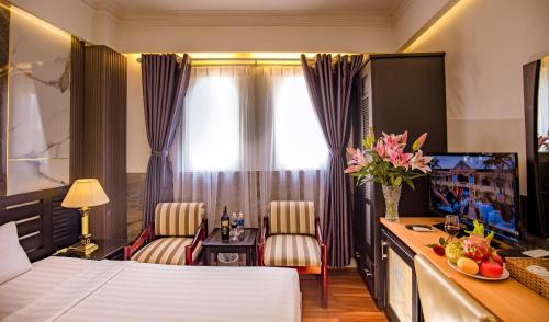 pokój hotelowy z łóżkiem, stołem i krzesłami w obiekcie Rosa Hotel & Spa w Ho Chi Minh