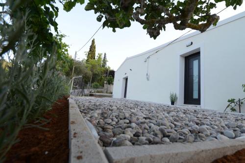 a white building with a stone path in front of it at Stablus house in Alykes Potamou