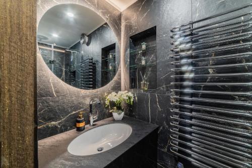 La salle de bains est pourvue d'un lavabo et d'un miroir. dans l'établissement E. D. Elite Apartment, à Šiauliai