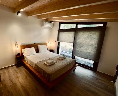 a bedroom with a large bed and a large window at Stablus house in Alykes Potamou
