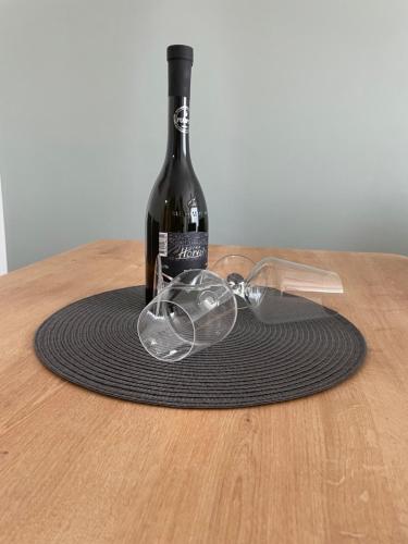 a bottle of wine and glasses on a table at Apartman Stela in Knin