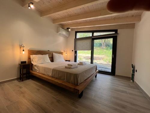 um quarto com uma cama grande e uma janela grande em Stablus house em Alykes Potamou