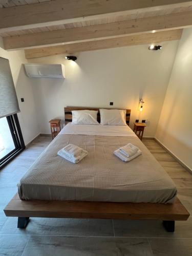 a bedroom with a large bed with two towels on it at Stablus house in Alykes Potamou
