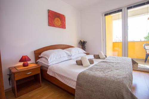 ein Schlafzimmer mit einem Bett und einem Tisch mit einer Lampe in der Unterkunft Apartman Vlado in Vrsar