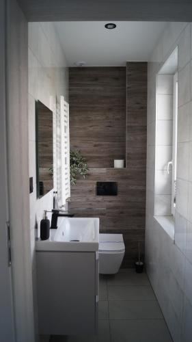 a bathroom with a white sink and a toilet at Pokoje do wynajęcia in Tomaszów Mazowiecki