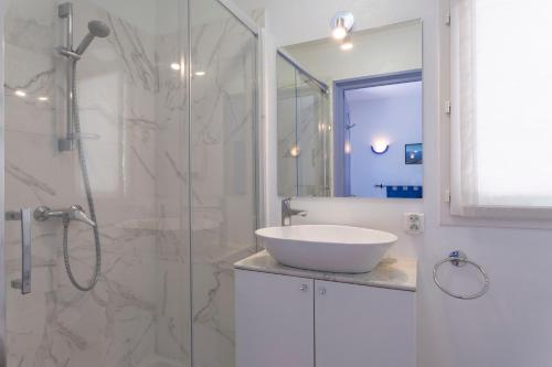 y baño blanco con lavabo y ducha. en Villa La Cigalette Gaiasvillas, en Théoule-sur-Mer