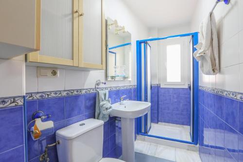 a blue and white bathroom with a toilet and a sink at Azahar Fibes in Seville