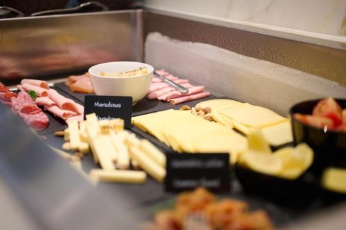Ein Haufen Fleisch und Käse auf einem Grill in der Unterkunft The CORNR Hotel in Nieuwpoort