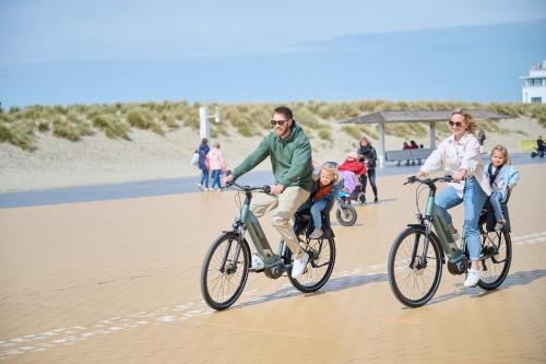 a group of people riding bikes on the beach at The CORNR Hotel in Nieuwpoort