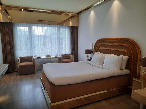 una camera da letto con un grande letto bianco e una finestra di Hotel Razmoni Isha Kha International a Dhaka