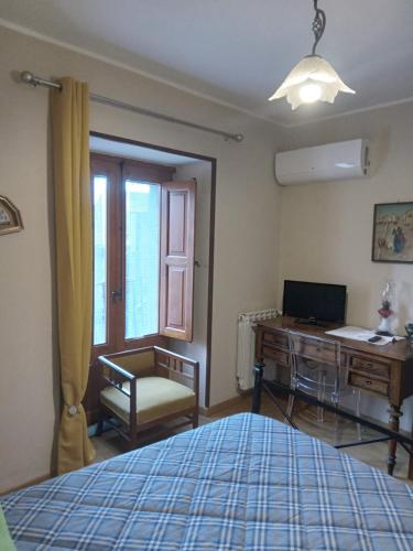 sypialnia z łóżkiem, biurkiem i komputerem w obiekcie San Nicolò Holiday Home w mieście Montalbano Elicona
