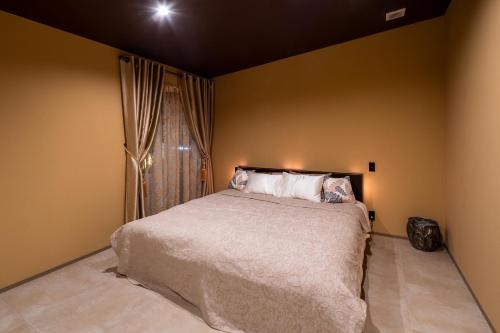 a bedroom with a bed and a window at 1日1組限定 展望露天風呂付き 南国リゾート貸切ヴィラ 歩羅无 湯河原 FuranYugawara in Yugawara