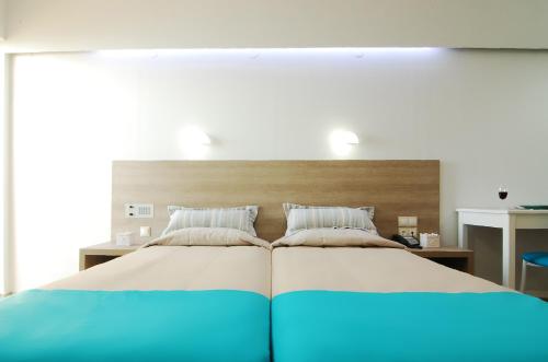a bedroom with a large bed with blue sheets at Medusa Apartments in Rethymno Town