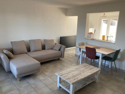 een woonkamer met een bank en een tafel bij Maison Saintes Maries de la Mer in Saintes-Maries-de-la-Mer