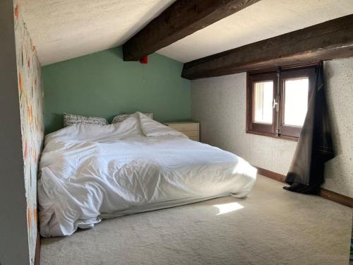 een slaapkamer met een wit bed en een raam bij Maison Saintes Maries de la Mer in Saintes-Maries-de-la-Mer