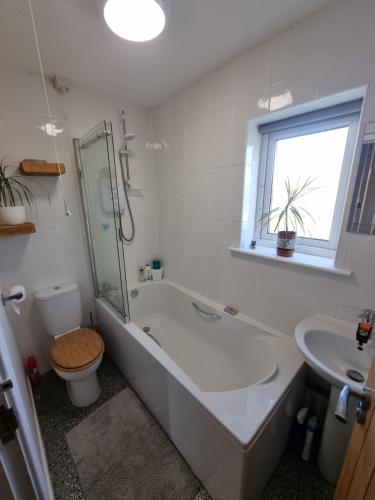 a bathroom with a tub and a toilet and a sink at Harlech apartment Castle view in Harlech