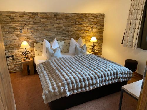 a bedroom with a large bed and a brick wall at Ferienwohnungen Jägerheim & Jägerhaus in Ehrwald