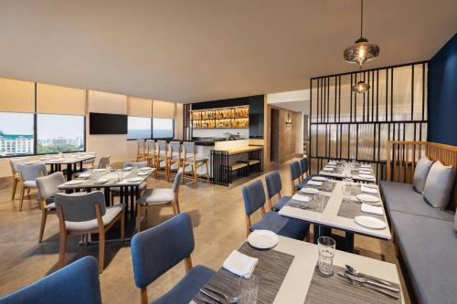 a restaurant with tables and chairs and a bar at Fairfield by Marriott Jaipur in Jaipur