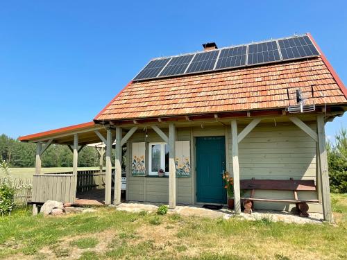 a small house with solar panels on the roof at POLNA CHATA in Jasionówka