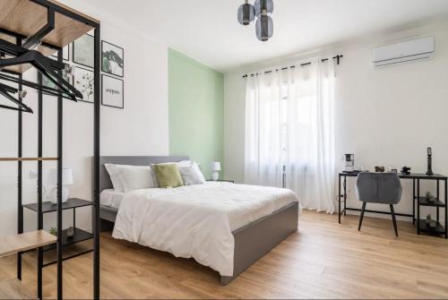 Habitación blanca con cama y escritorio en Beno House Brescia en Brescia
