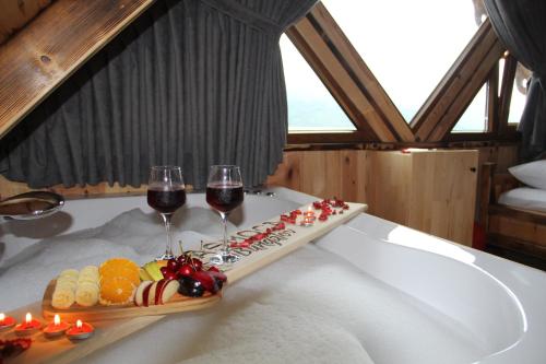 una bandeja de comida y dos copas de vino en Asmoca Bungalov, en Rize