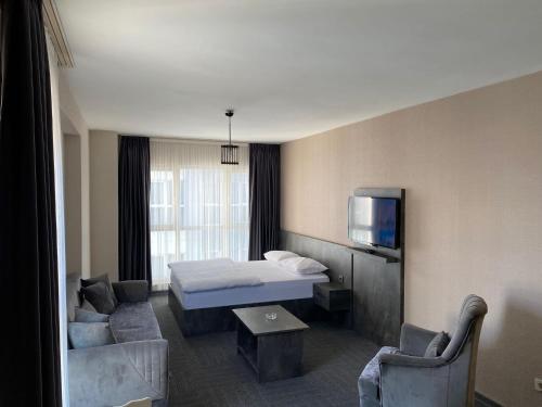 a hotel room with a bed and a tv at Pin Suite Hotel in Kırac