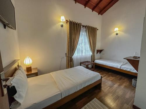1 dormitorio con 2 camas y una ventana con cortinas en Grace en Nuwara Eliya