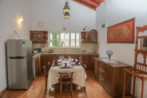 a kitchen with a table and a refrigerator at Grace in Nuwara Eliya