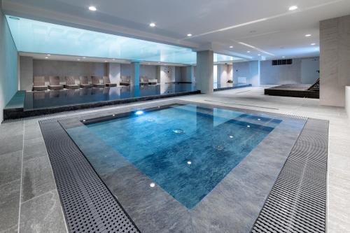 a large swimming pool in the middle of a building at Kazalnica Family&Conference Resort in Sosnówka