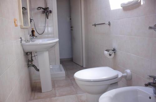 uma casa de banho com um WC branco e um lavatório. em LE CASTELLA BEACH S.F.2 em Le Castella