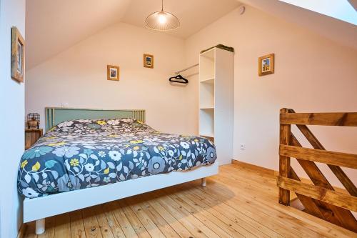 een slaapkamer met een bed en een houten vloer bij Le duplex contemporain in Pontarlier