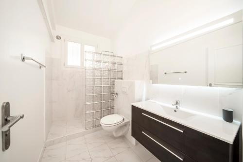 a white bathroom with a sink and a toilet at Villa La Cigale Gaia's Villas in Théoule-sur-Mer