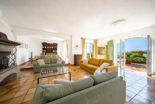 a living room with couches and a fireplace at Villa La Cigale Gaia's Villas in Théoule-sur-Mer